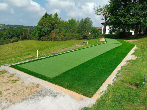 Naperville Outdoor tee line consisting of one continuous green synthetic grass strip surrounded by trees